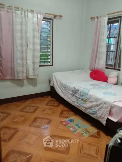 Cozy bedroom with tiled floor and colorful bedding, perfect for a child's room.