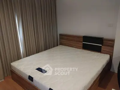Spacious bedroom with modern wooden bed frame and large window with curtains