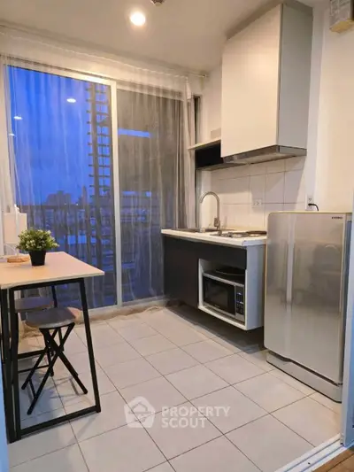 Modern kitchen with open layout and city view, featuring sleek appliances and stylish decor.