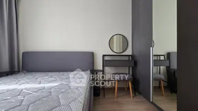 Modern bedroom with stylish furniture and cozy ambiance, featuring a sleek bed and mirrored wardrobe.