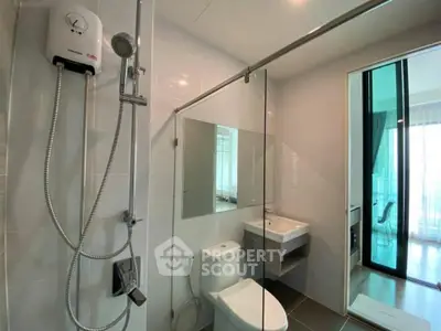 Modern bathroom with glass shower and sleek fixtures in a contemporary apartment.