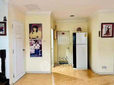 Charming interior with fridge and decorative wall art in cozy living space.