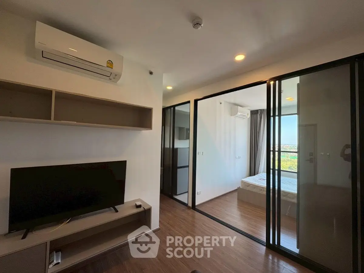 Modern apartment interior with living room and bedroom, featuring sleek design and natural light.