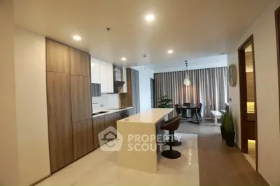 Modern open kitchen with sleek design and dining area, featuring a stylish breakfast bar and elegant lighting.