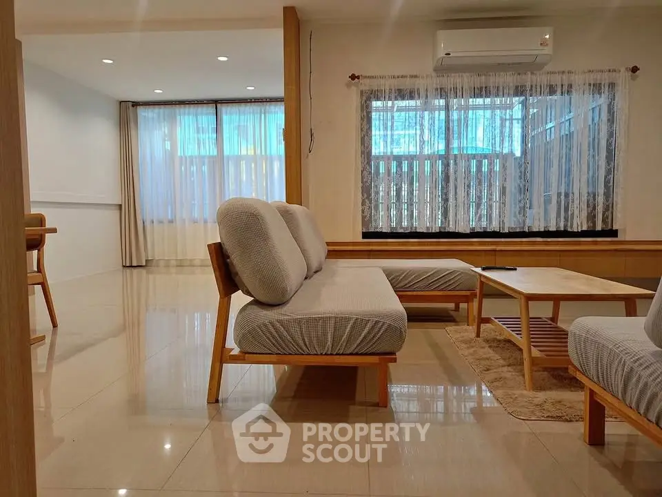 Spacious modern living room with elegant furniture and large windows for natural light.
