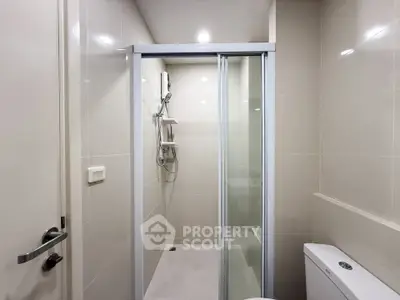 Modern bathroom with sleek shower enclosure and neutral tiles