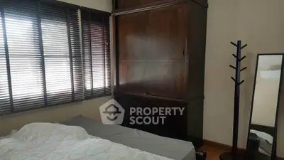 Cozy bedroom with wooden wardrobe and large window blinds