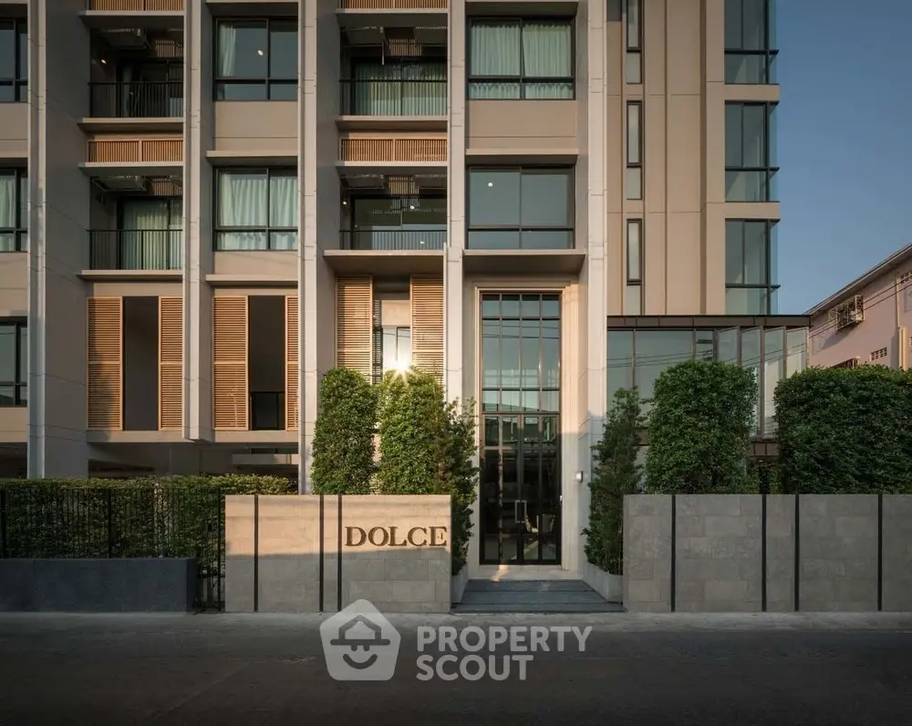 Elegant modern building facade with lush greenery and stylish entrance