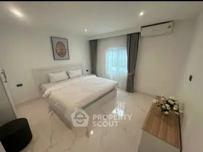 Modern bedroom with elegant decor and natural light, featuring a cozy bed and stylish furnishings.