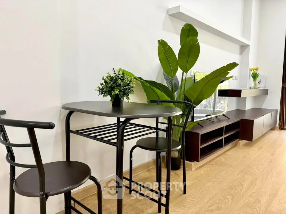 Modern living room with stylish furniture and indoor plants, featuring a sleek TV stand and elegant decor.