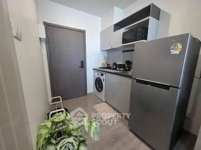 Modern kitchen with sleek appliances and washing machine in compact layout