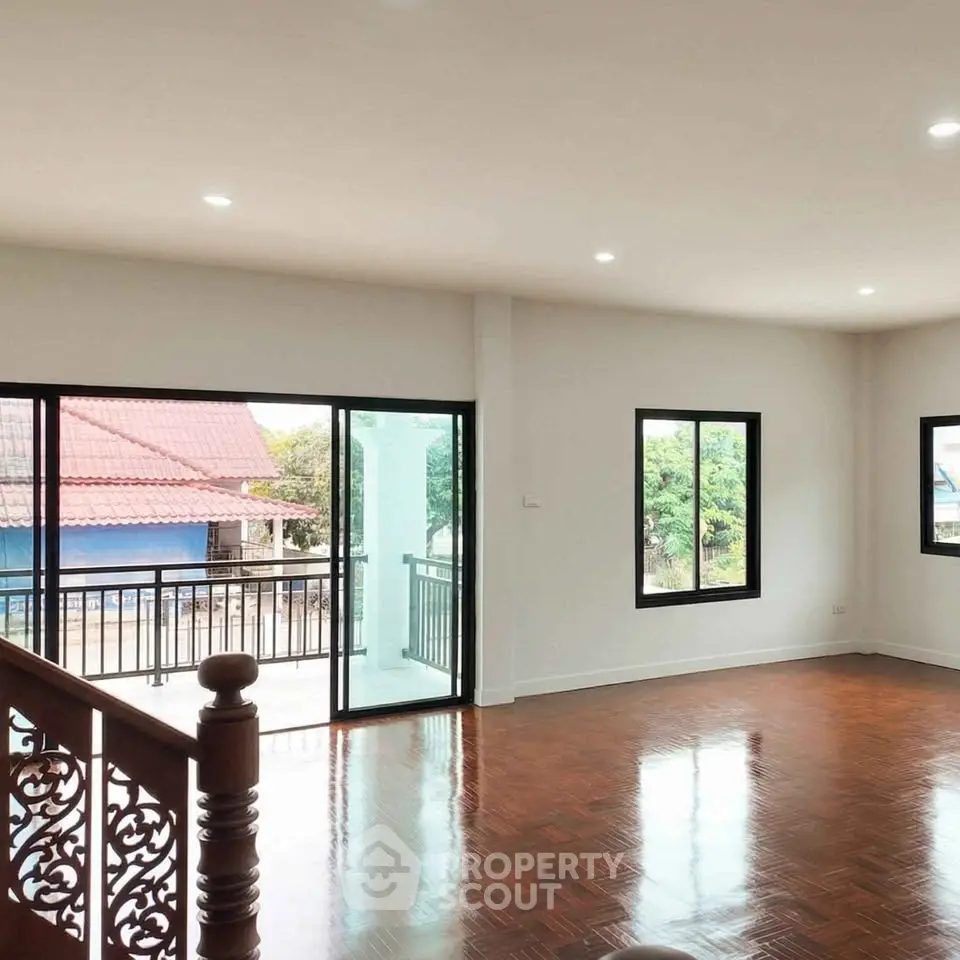 Spacious living room with polished wooden floors and balcony access