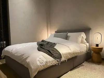Cozy bedroom with modern decor and ambient lighting, featuring a plush bed and stylish side table.