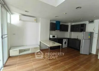 Modern kitchen with appliances including fridge, microwave, and washing machine in a sleek open layout.
