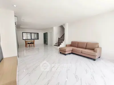 Spacious modern living room with elegant marble flooring and cozy seating area.