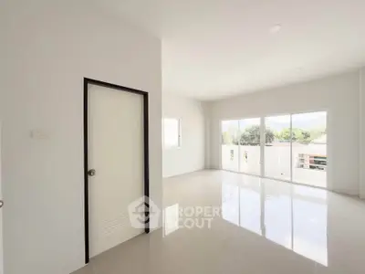 Spacious and bright living room with large windows and glossy floors in modern home.