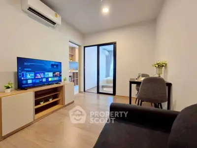 Modern living room with sleek furniture and smart TV in a cozy apartment setting.