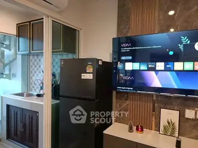 Modern living room with smart TV and kitchen view in stylish apartment