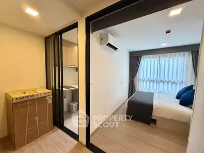 Modern bedroom with air conditioning and compact kitchen in a stylish apartment.
