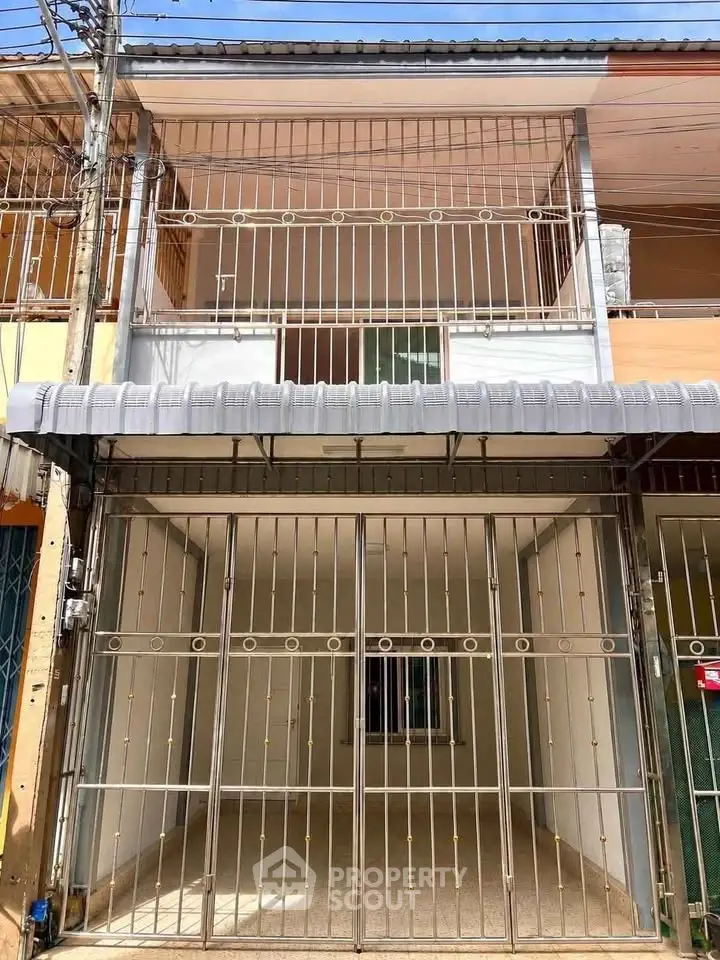 Charming two-story townhouse with gated entrance and balcony, perfect for urban living.