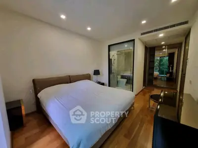 Spacious bedroom with ensuite bathroom and modern decor in luxury apartment.