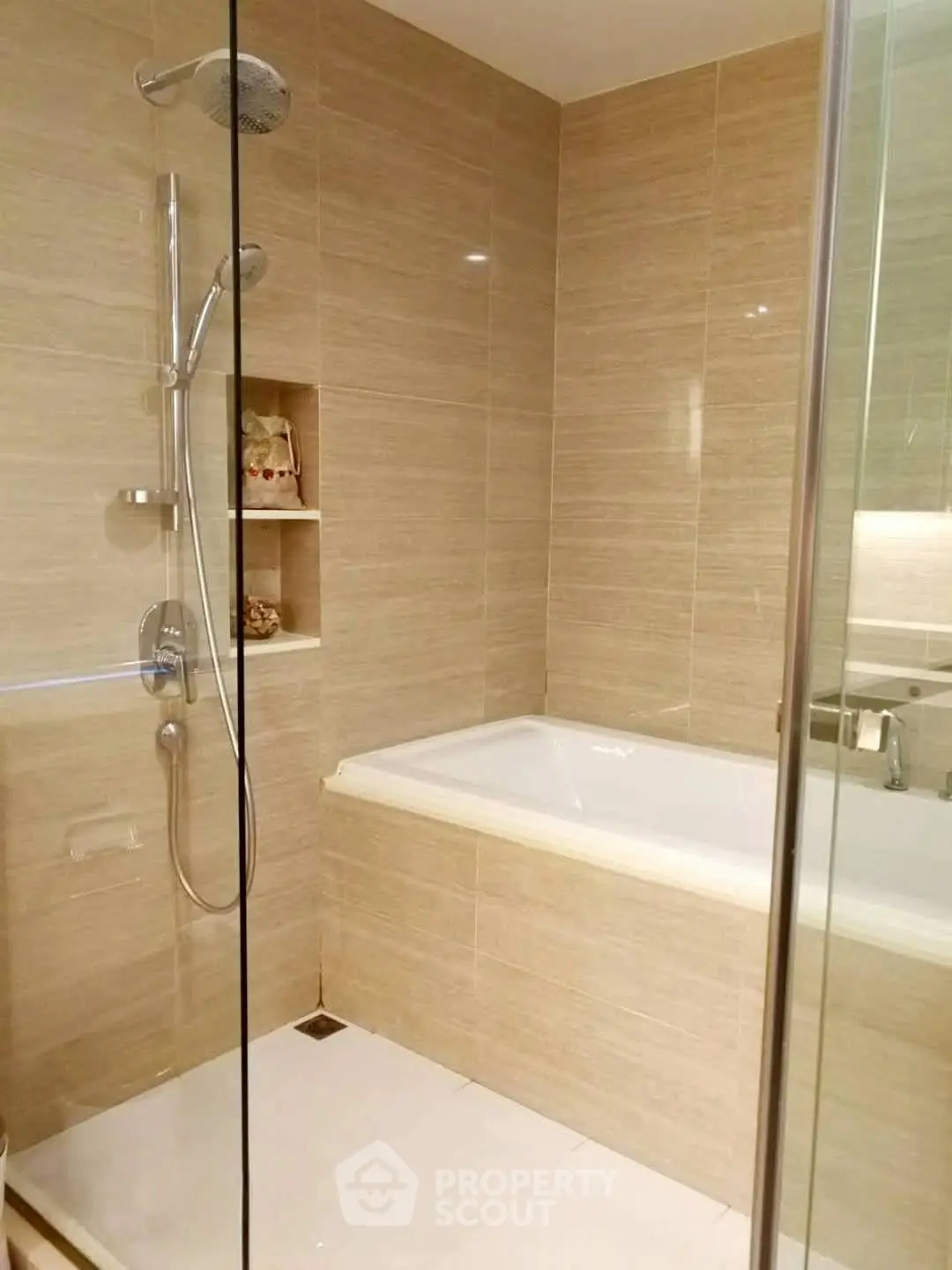 Modern bathroom with elegant beige tiles and built-in bathtub