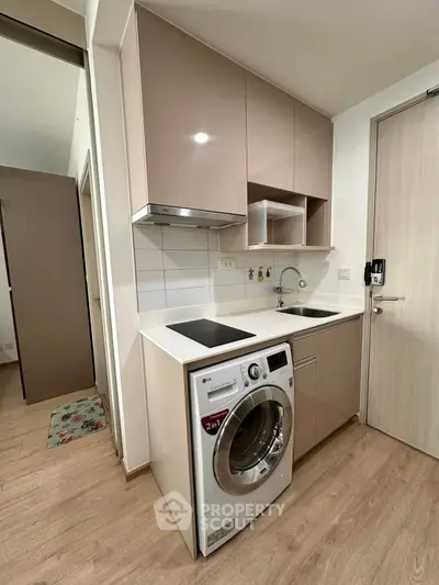 Modern compact kitchen with integrated washing machine and sleek cabinetry