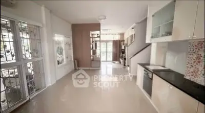 Spacious open-plan living area with modern kitchen and large windows for natural light.