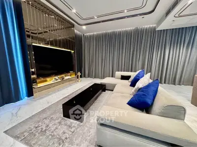 Luxurious modern living room with plush sofa and large TV, perfect for relaxation.