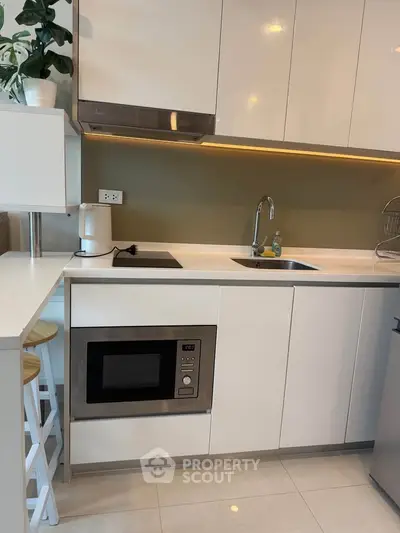 Modern kitchen with sleek cabinetry and built-in microwave