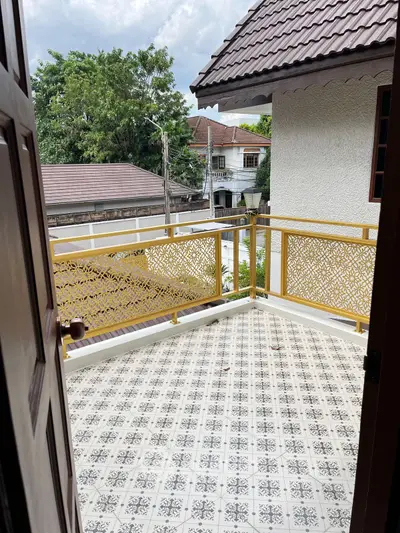 Charming balcony with decorative railing and patterned tile flooring, offering a cozy outdoor space.