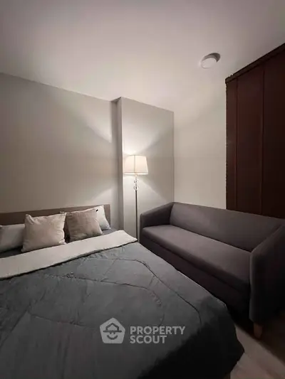 Cozy bedroom with modern decor, featuring a comfortable bed and stylish sofa for ultimate relaxation.