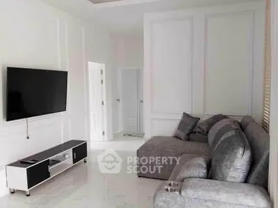 Modern living room with sleek gray sofa and wall-mounted TV