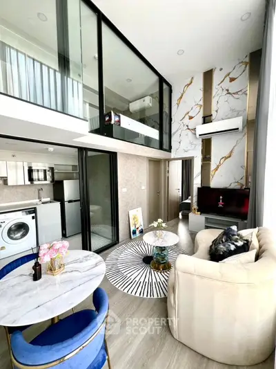 Luxurious modern living room with mezzanine, marble accents, and open kitchen layout.