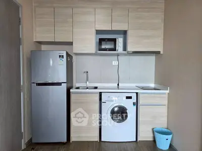 Modern compact kitchen with appliances including fridge, microwave, and washing machine.