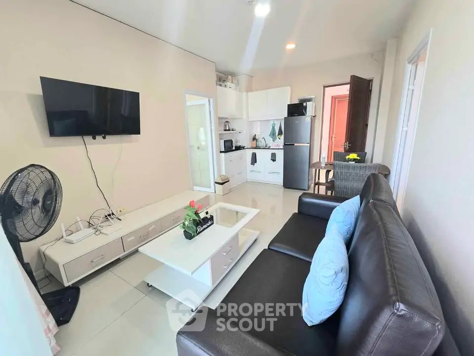 Modern living room with sleek furniture and wall-mounted TV in a cozy apartment.
