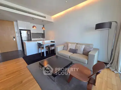 Modern living room with open kitchen, stylish furniture, and cozy lighting