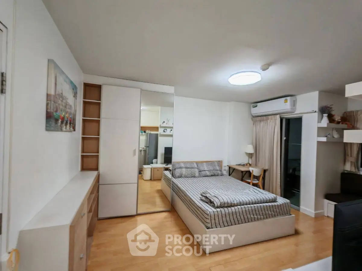 Modern bedroom with stylish decor and ample storage in a cozy apartment.