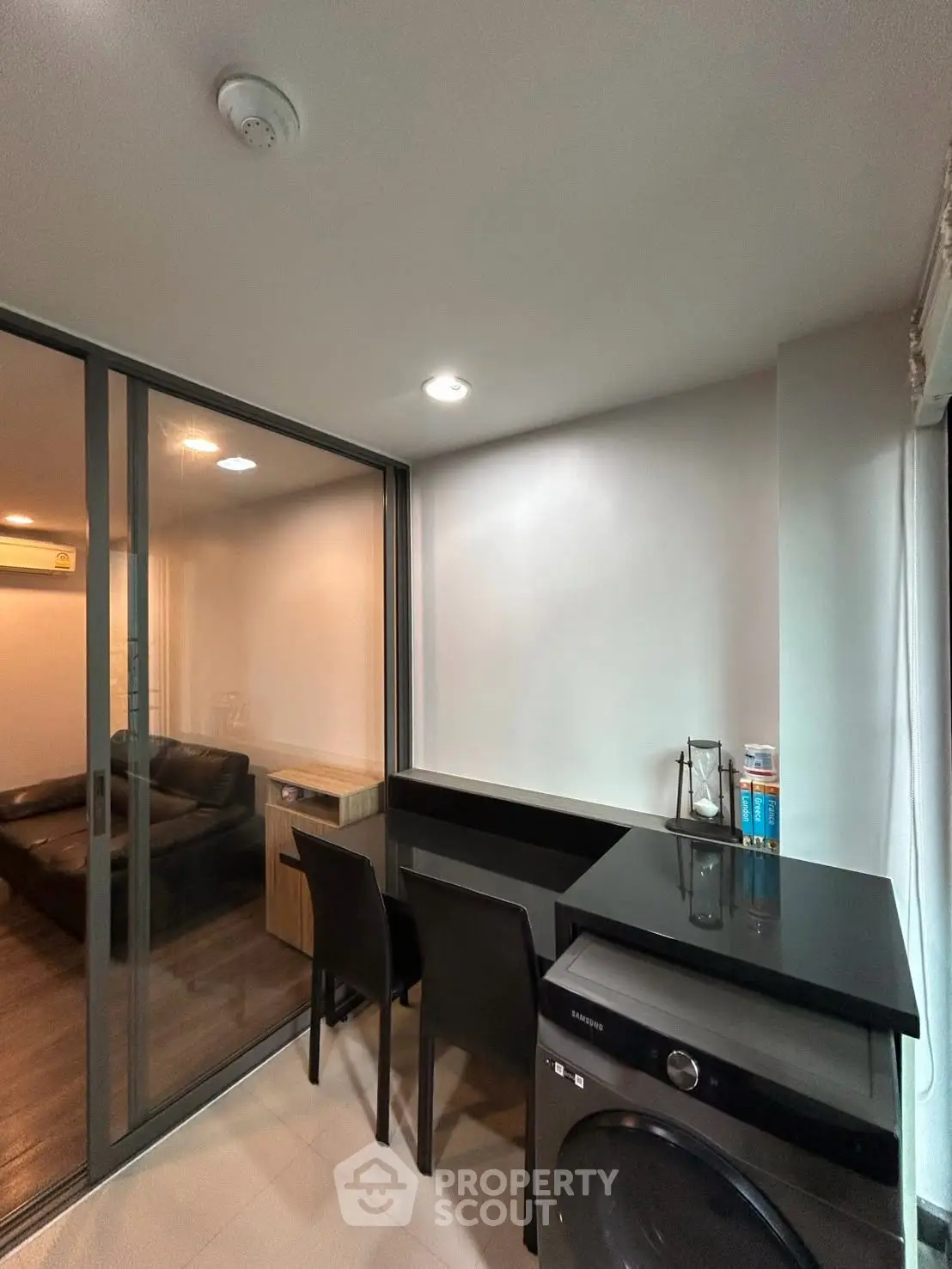 Modern condo with sleek interior design featuring a compact dining area and washing machine.