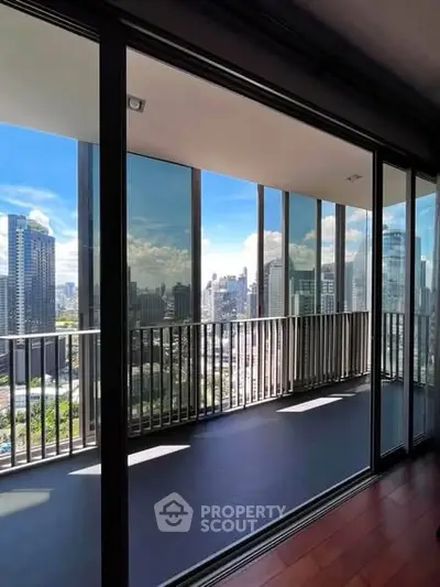 Stunning city view from a modern high-rise balcony with glass railings and sleek design.