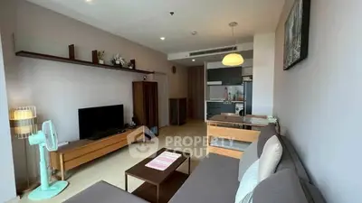 Modern living room with stylish furniture and open kitchen layout in a cozy apartment.