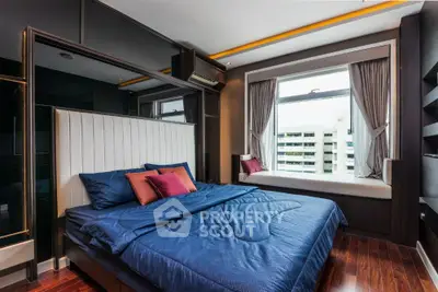 Luxurious bedroom with modern design and large window offering city view, featuring elegant bedding and stylish decor.