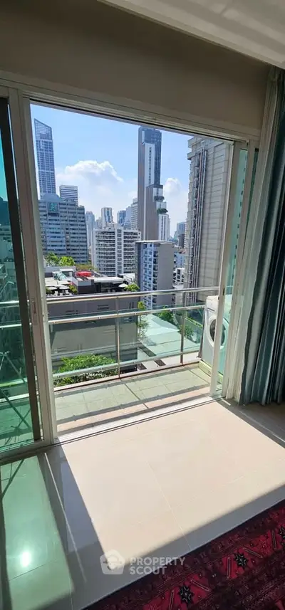 Stunning city view from a modern apartment balcony with glass railing.