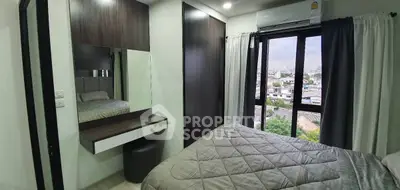 Modern bedroom with city view, featuring sleek furniture and large window for natural light.