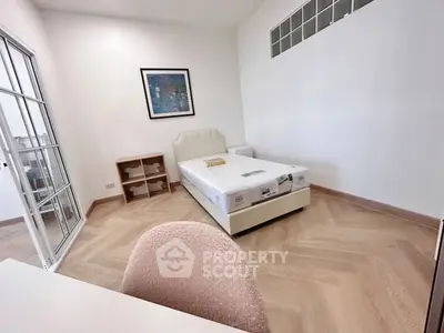 Spacious bedroom with modern decor and natural light, featuring a comfortable bed and stylish flooring.