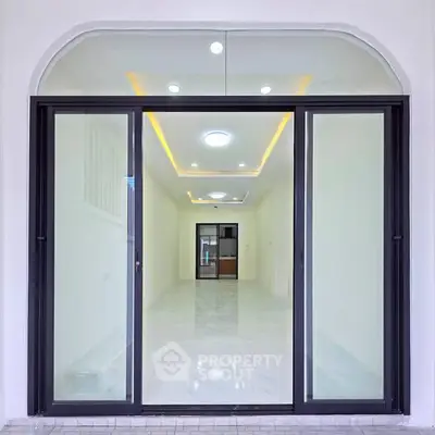 Modern interior with sleek glass doors and recessed lighting, showcasing a spacious and elegant design.