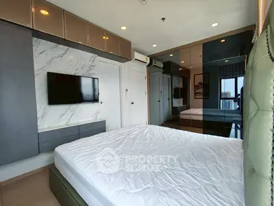 Luxurious modern bedroom with stylish decor and city view, featuring a wall-mounted TV and ample storage.