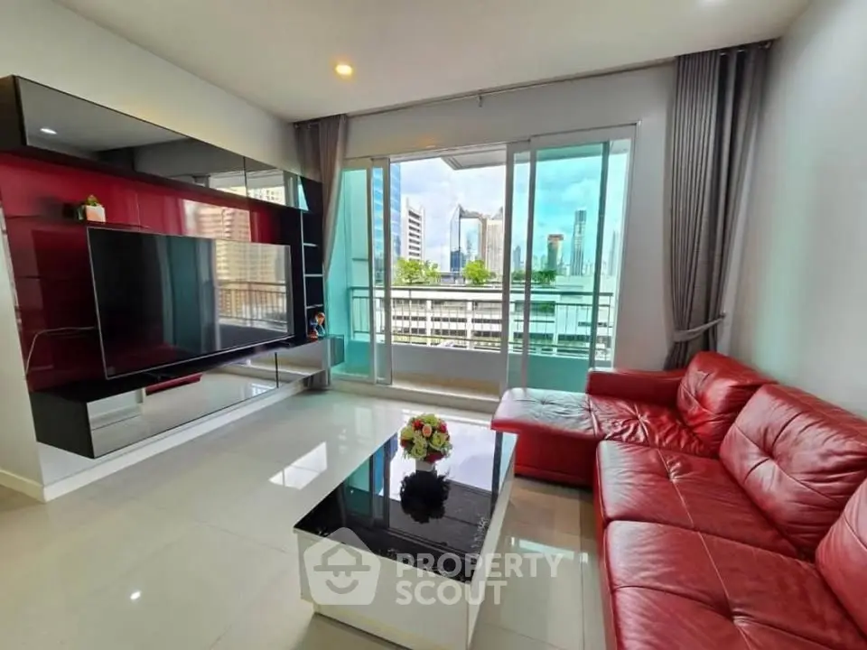 Modern living room with red leather sofa and city view balcony in high-rise apartment.