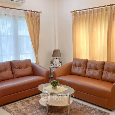 Cozy living room with stylish brown sofas and elegant curtains, perfect for relaxation and entertaining.