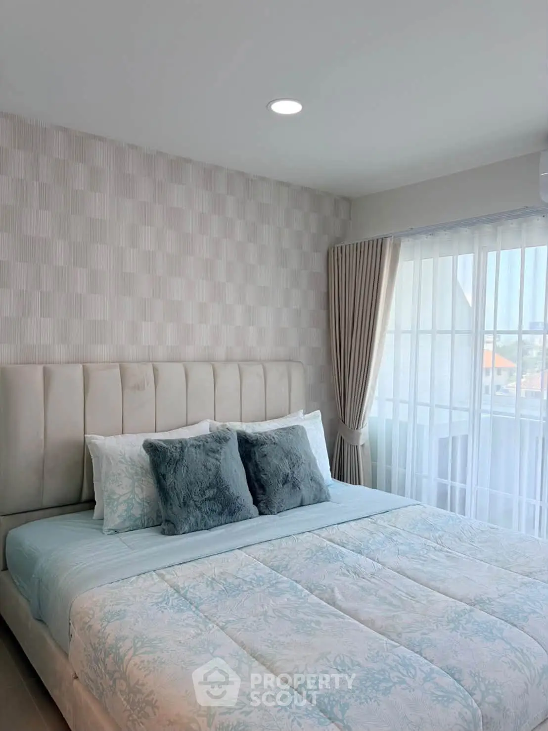 Cozy bedroom with elegant decor and large window for natural light
